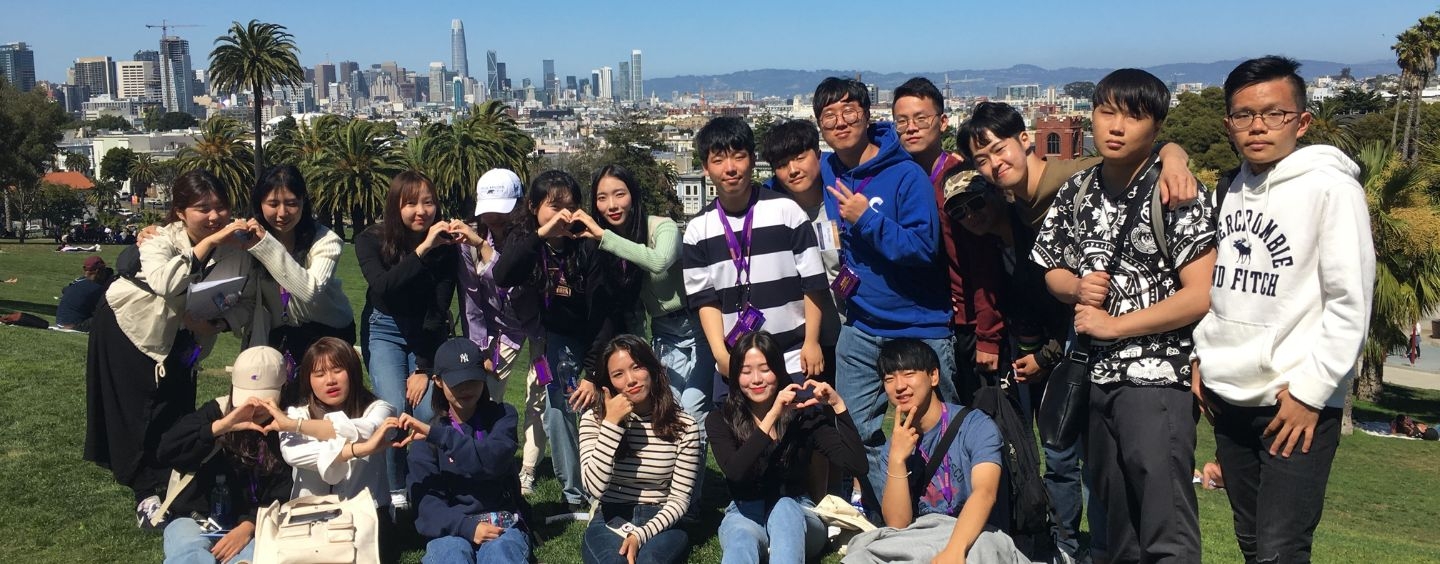 International students at Dolores Park, with a cityscape behind them