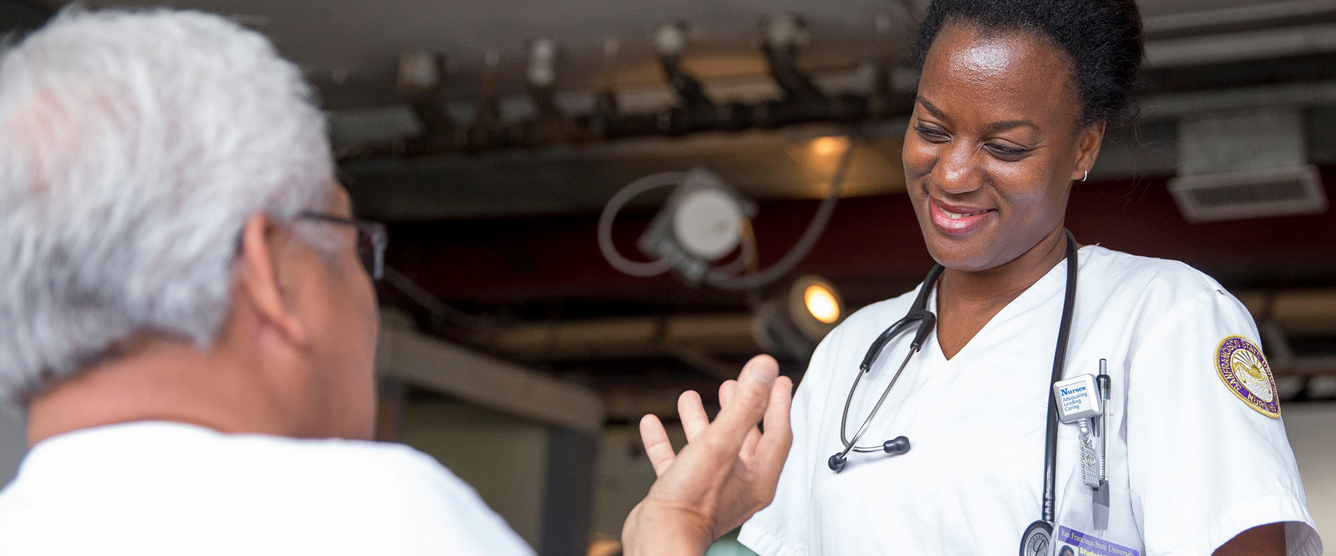 FNP student nurse smiles while listening to patient