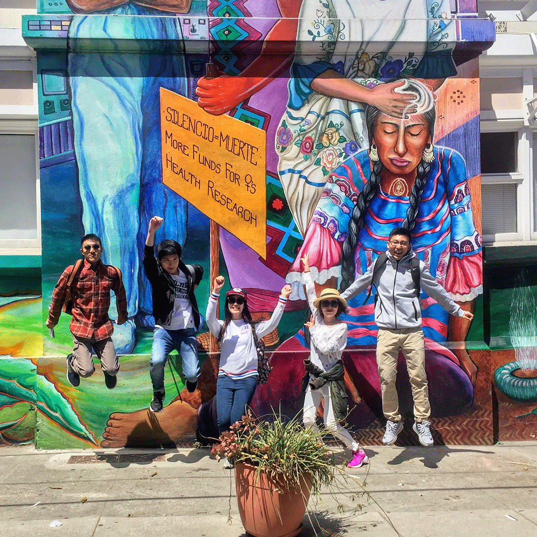 International student jump up in front of the Women's Building mural