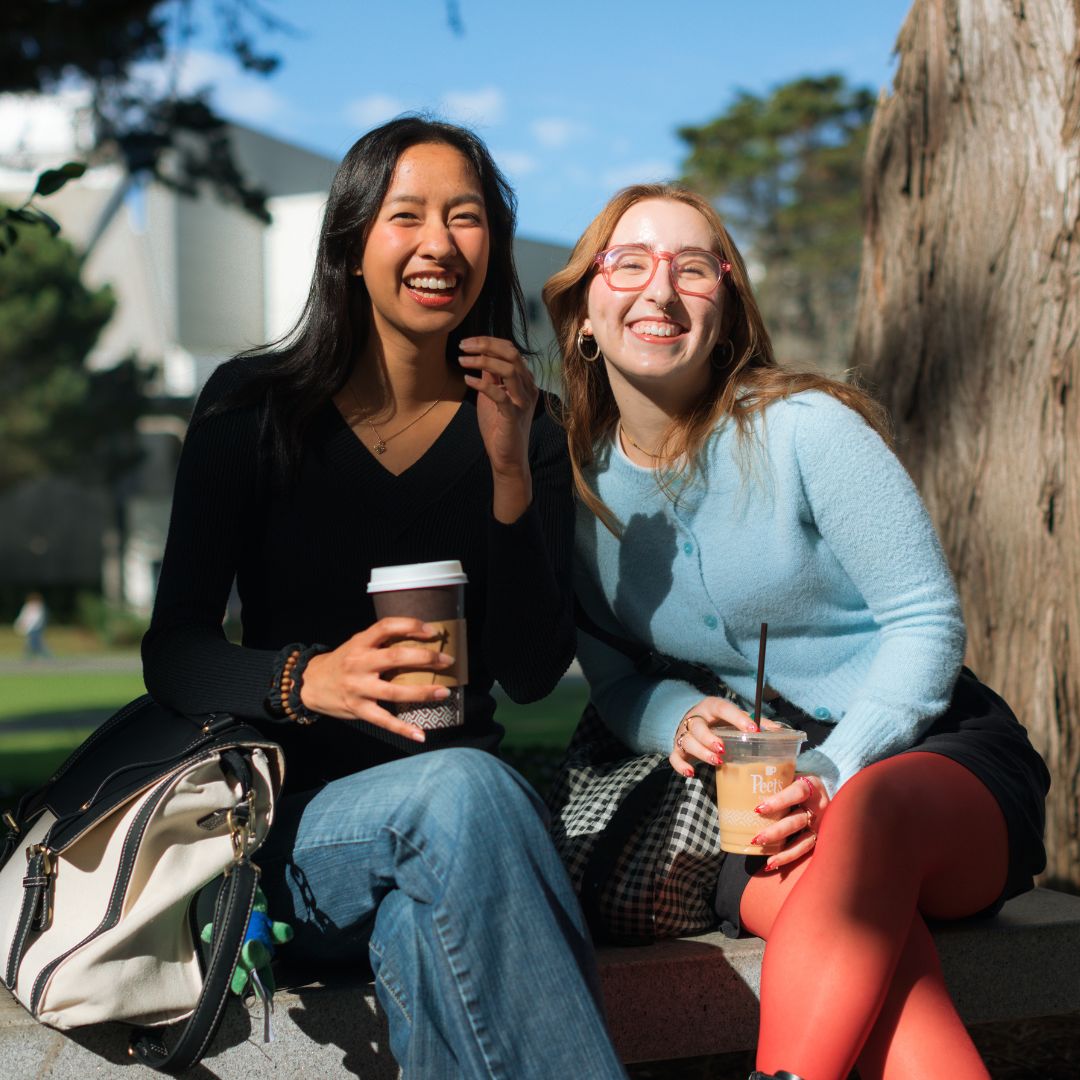 Students sit together in the shade on the SFSU campus