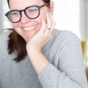 Instructional designer taking an online course, smiles while looking at laptop