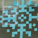 A dorm window with a winter snowflake formed from blue Post-It notes