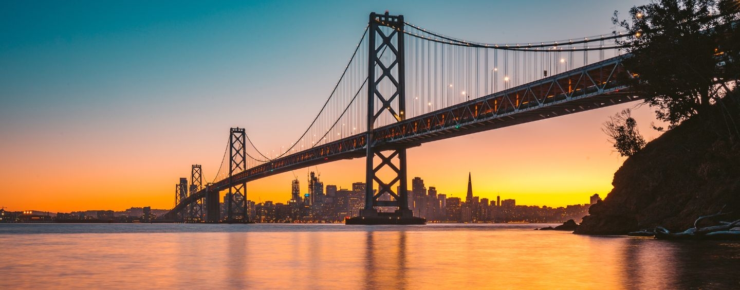 Bay Bridge at sunset, with the San Francisco skyline in the distance