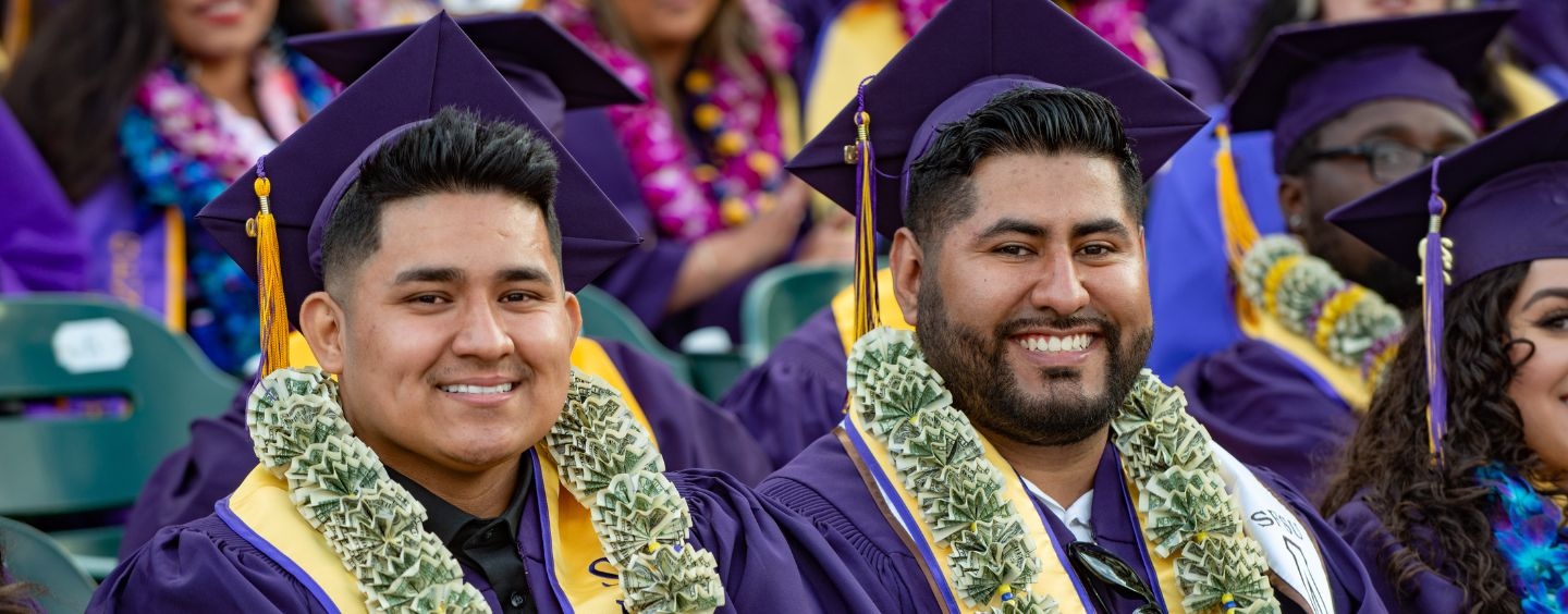 Business students wearing money leis at Commencement