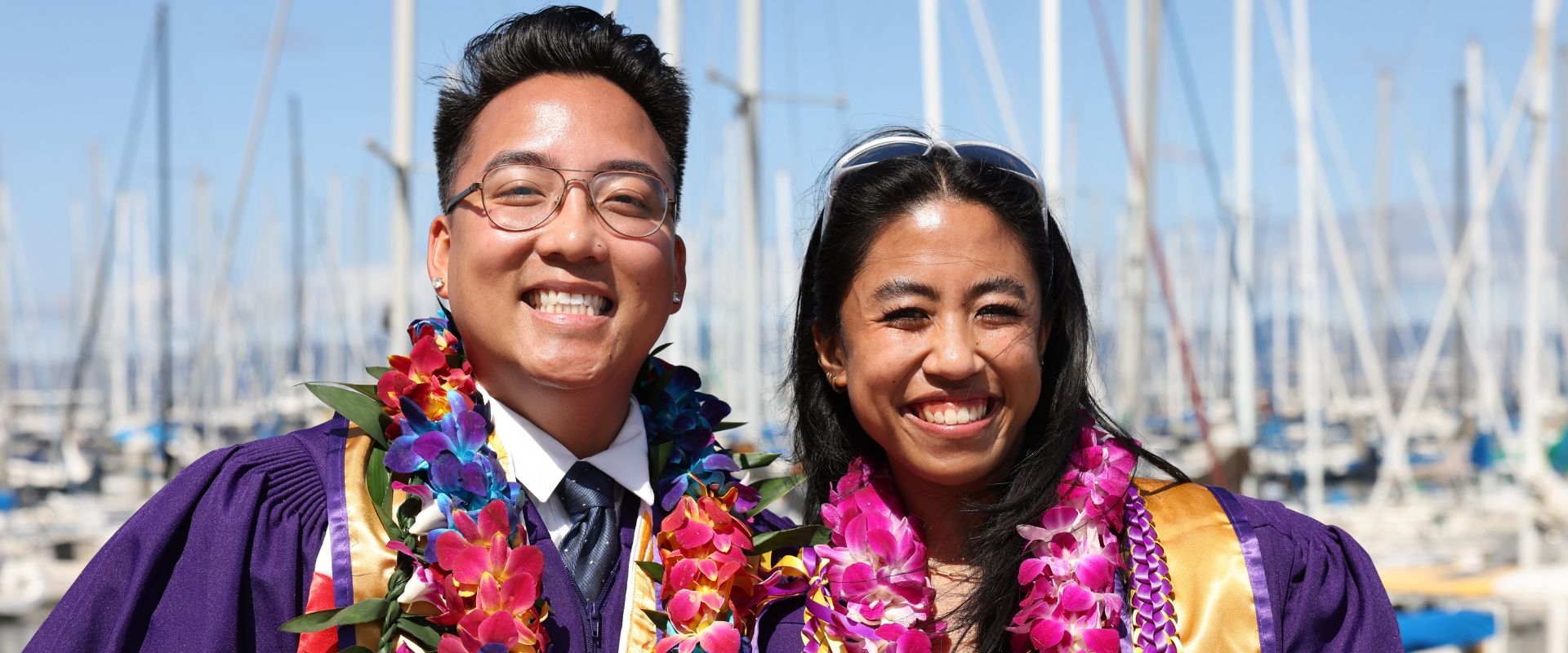 Graduates in leis and regalia at the marina