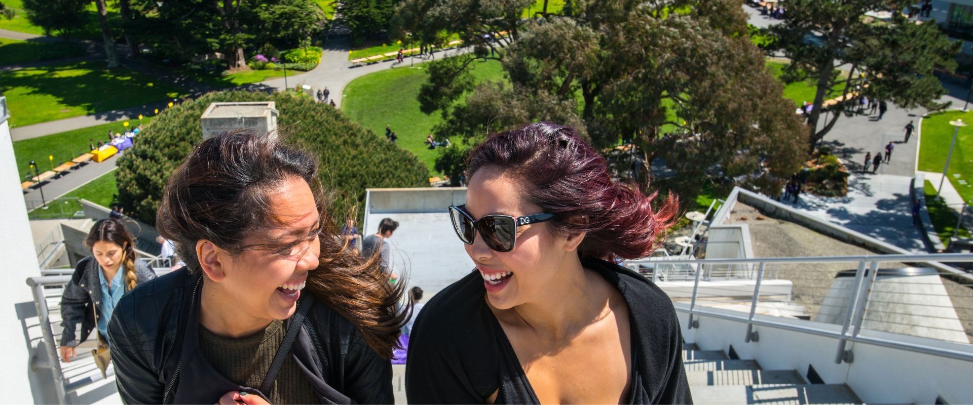 Students standing on the stairs atop the Student Center, with the campus beneath them