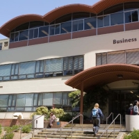 Marketing student walks up the steps to the Business building