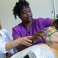 CMA student and teacher administer oxygen on medical dummy