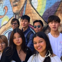 International student sin front of a Jackie Chan dragon mural in Chinatown