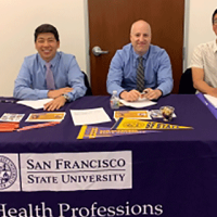 Three staff at table during event