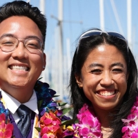 SF State graduates in leis and regalia at a marina