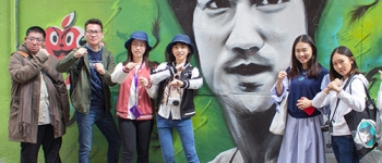 International students pose at the Bruce Lee mural.